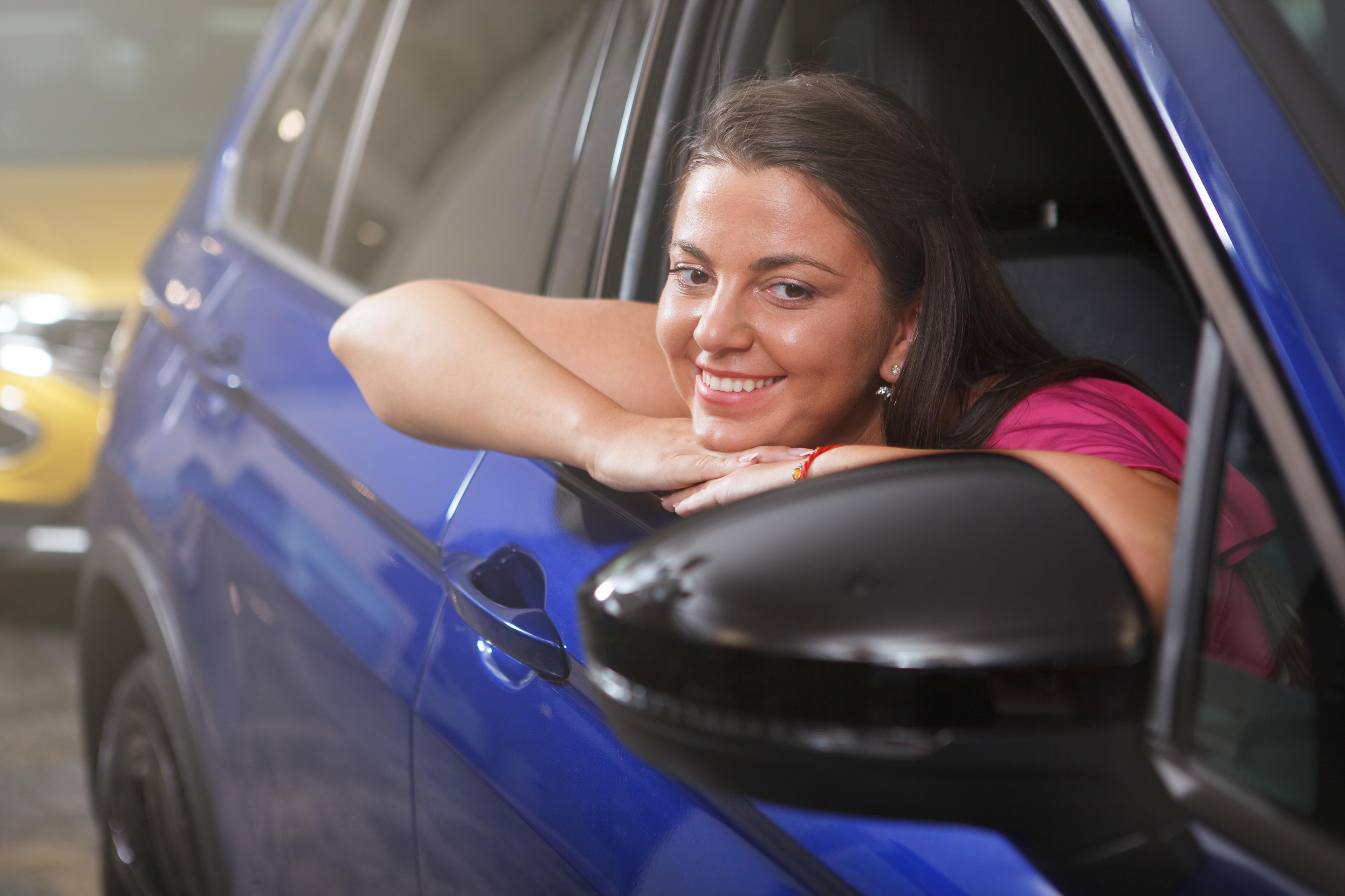 Happy customer seated in her vehicle after completing purchase and registration steps